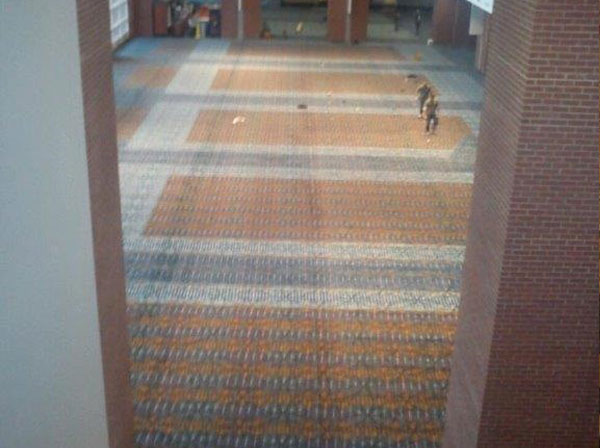 A hallway with two dogs walking on the carpet.